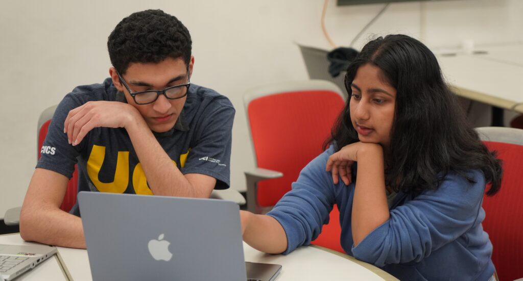 An OAI learning mentor (male) is working with a female student